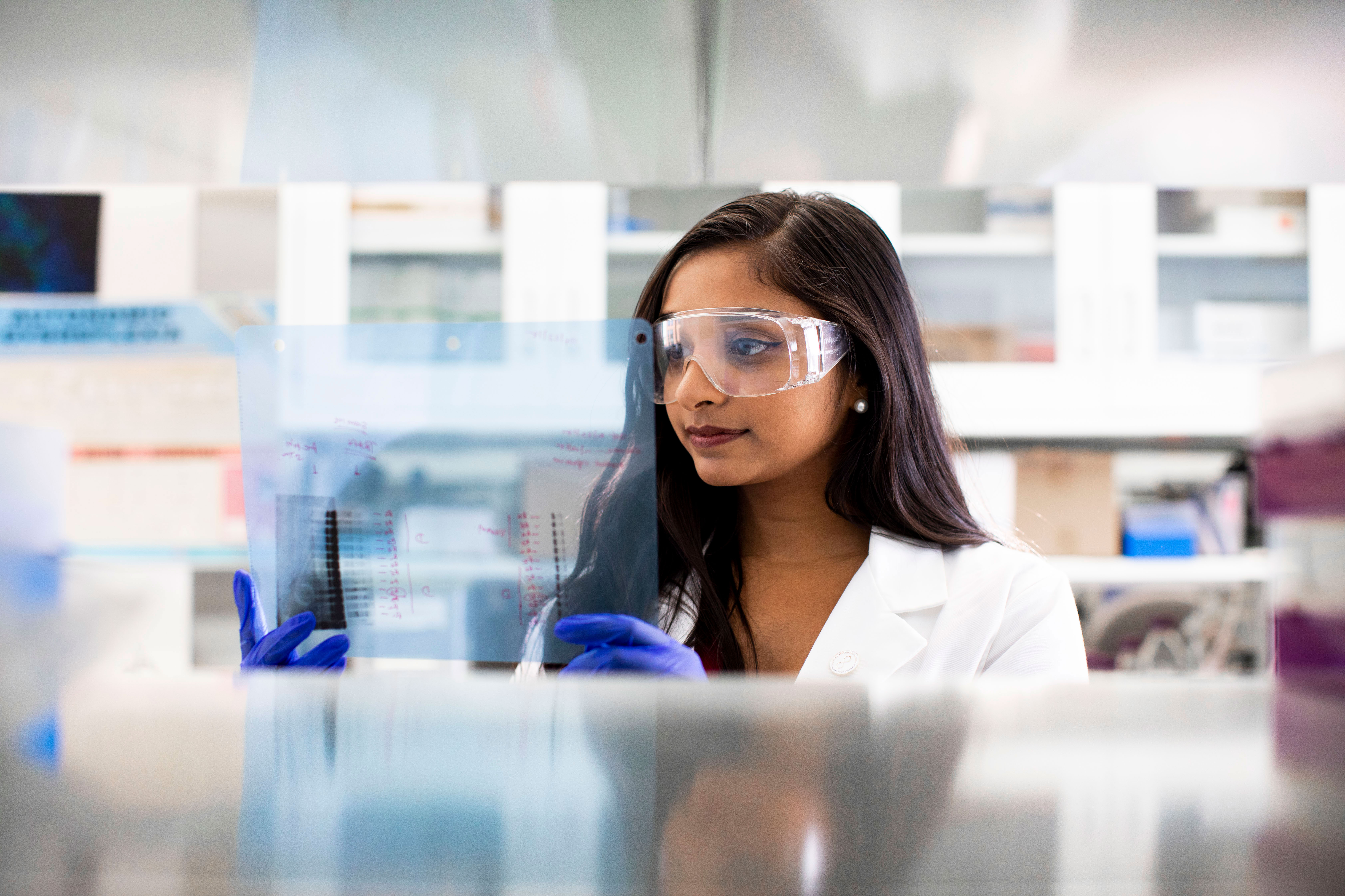 image of woman wearing white coat in lab setting 