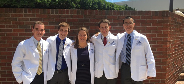 5 UK students posing with their white coats