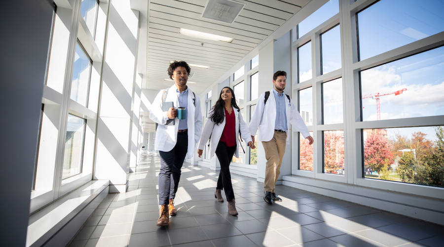 3 medical students walking down a hallway