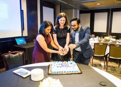 Graduated fellows Pratibha, Monika, and Ahsan cut into their graduation cake.