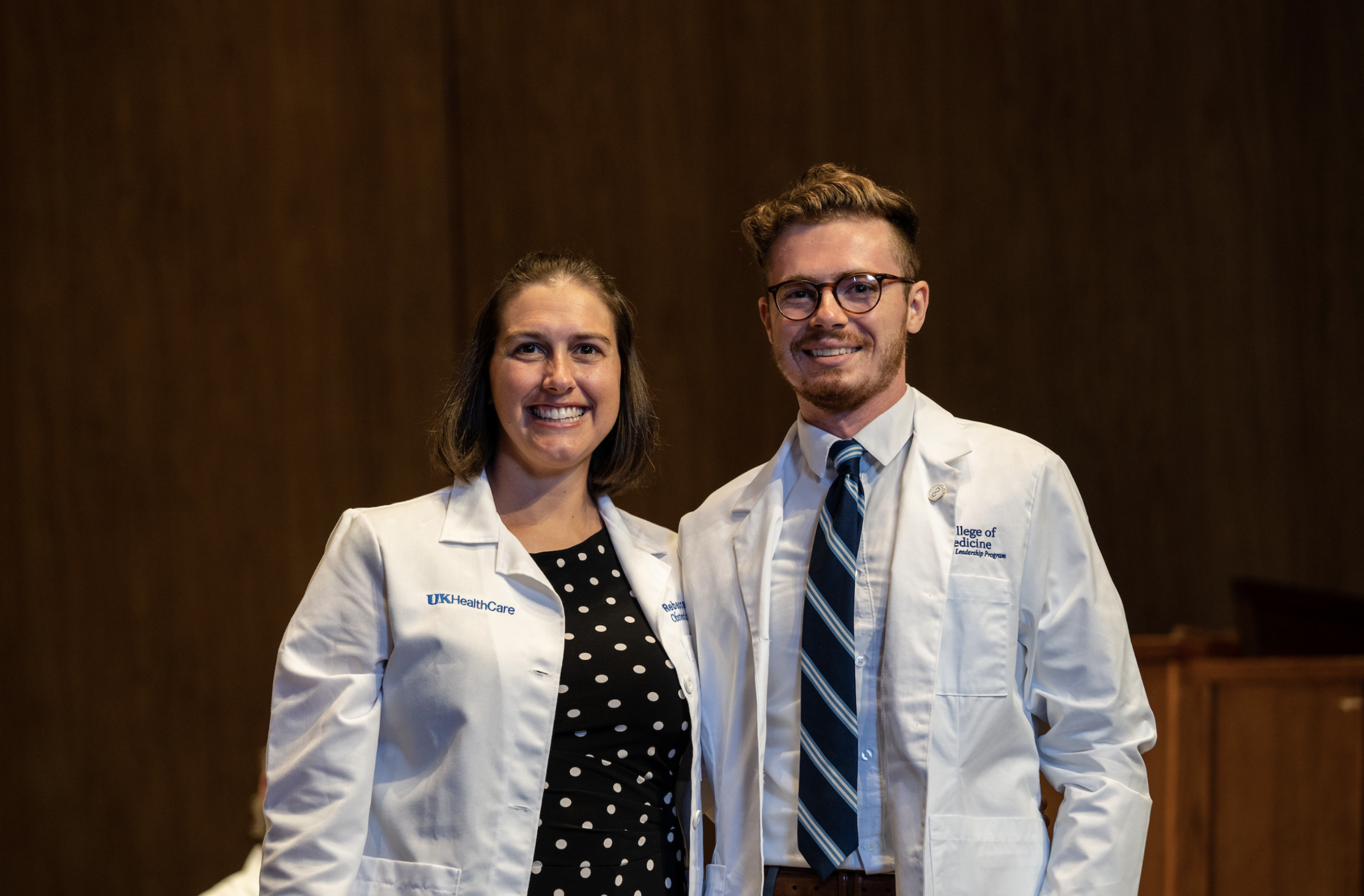 a student posing after receiving their white coat at medical school orientation