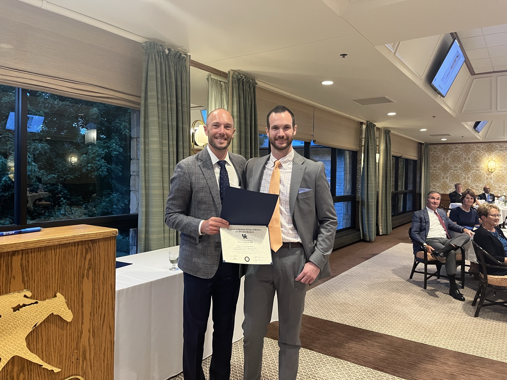 Ortho resident with faculty member receiving some sort of award or recognition