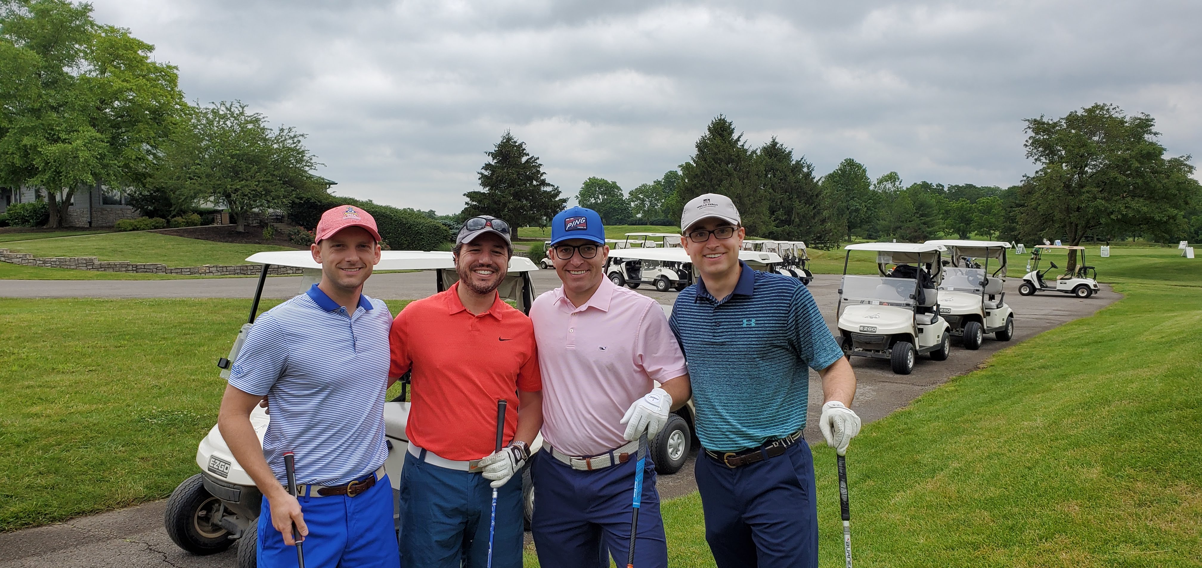 group picture of ortho residents on a golf course with golf carts in background