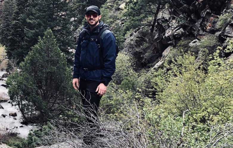 Jeremy Swiney standing in a forested valley