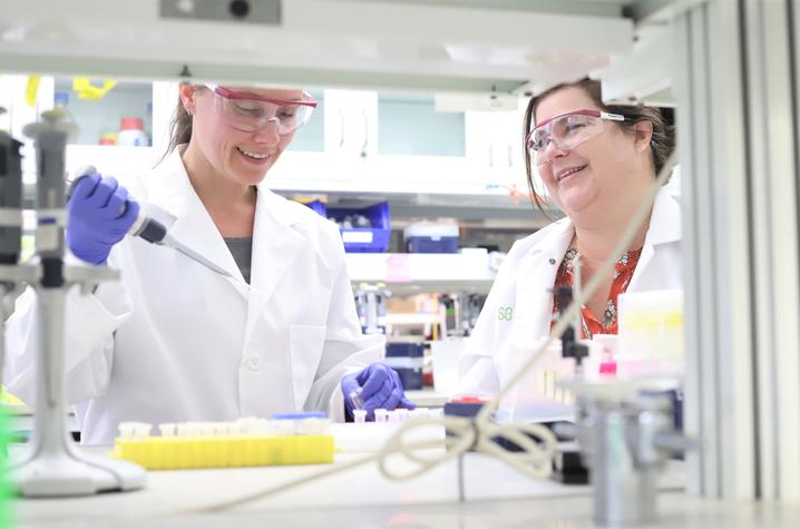 Jessica Blackburn and Yelena Chernyavskaya working together in a lab.