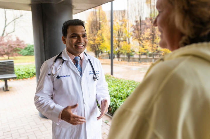 Amit Arbune, MD, speaking with a patient 