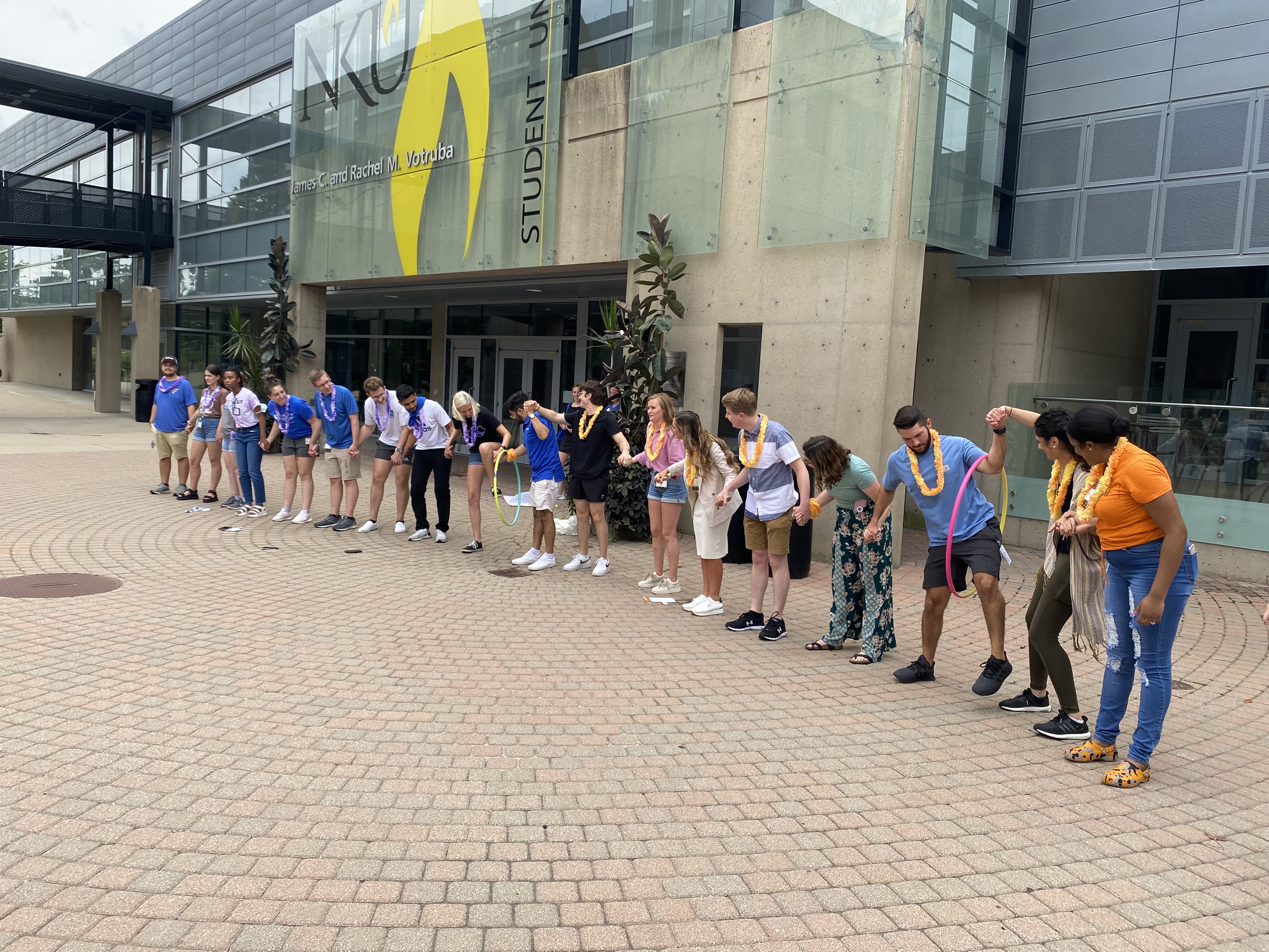 students stand in a line outside 