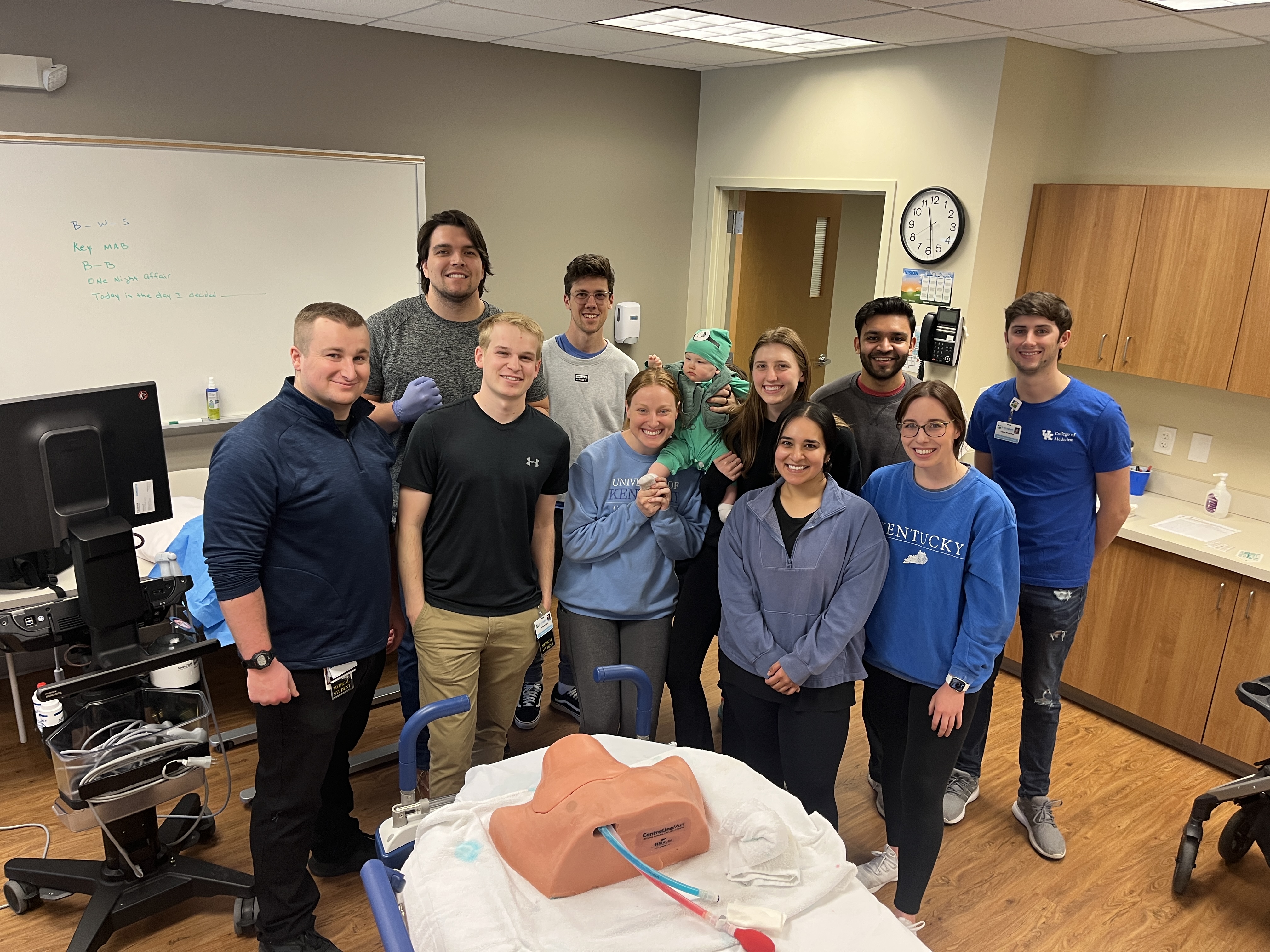 students and residents pose in a simulation room