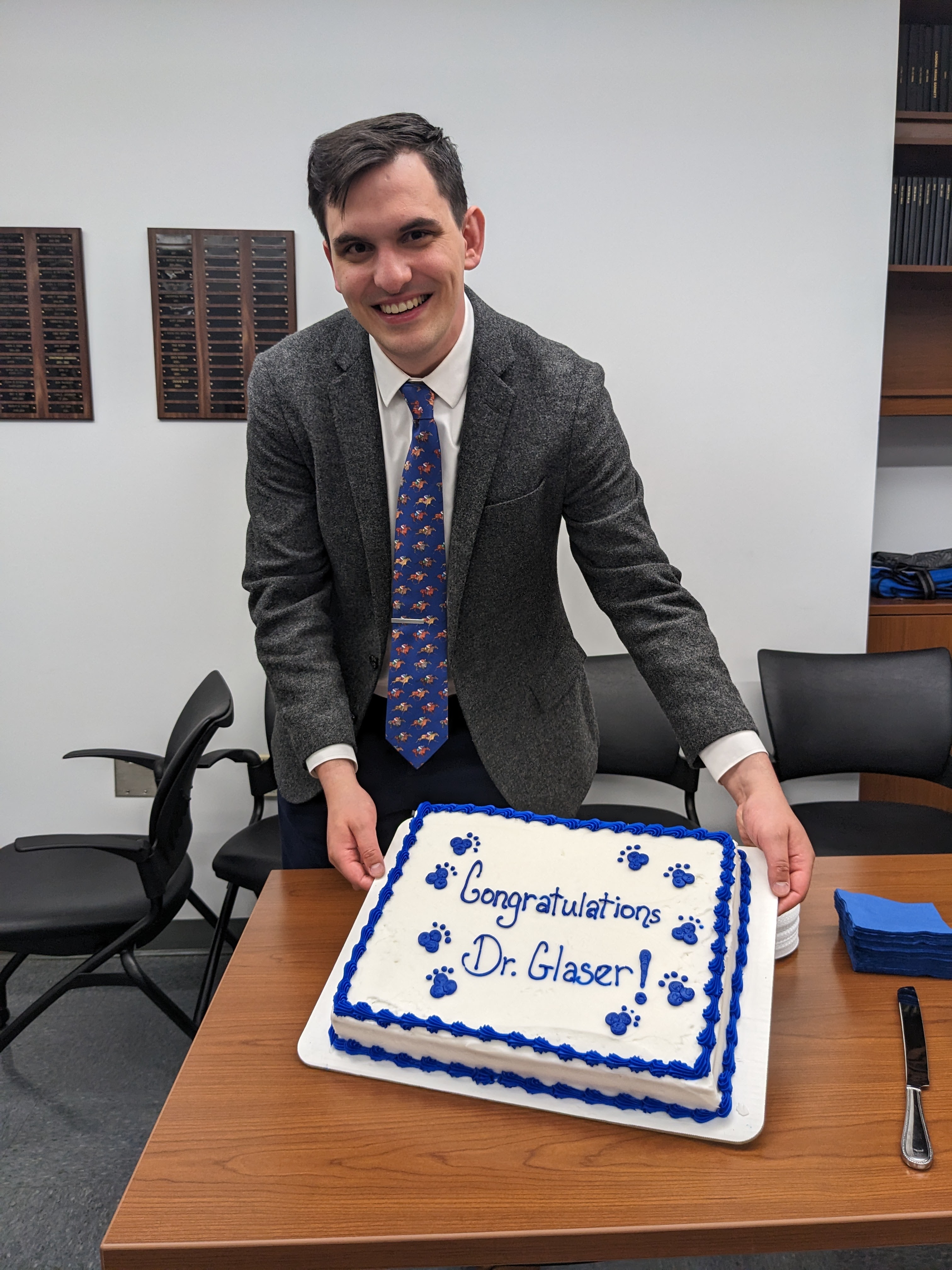 Ethan Glaser holding a cake that says "Congratulations Dr Glaser!"