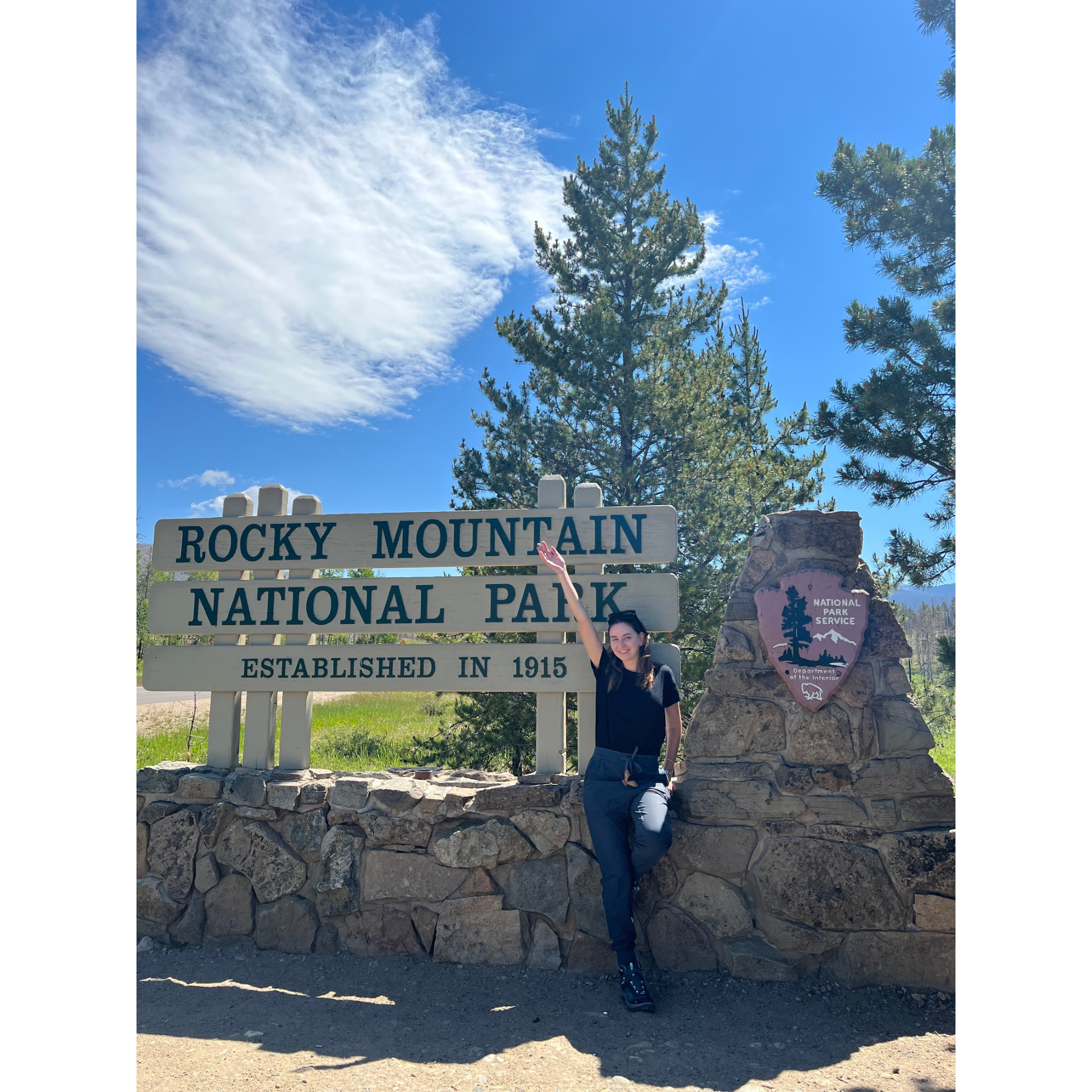 Diana Khair standing in front of the Rocky Mountain National Park sign. 