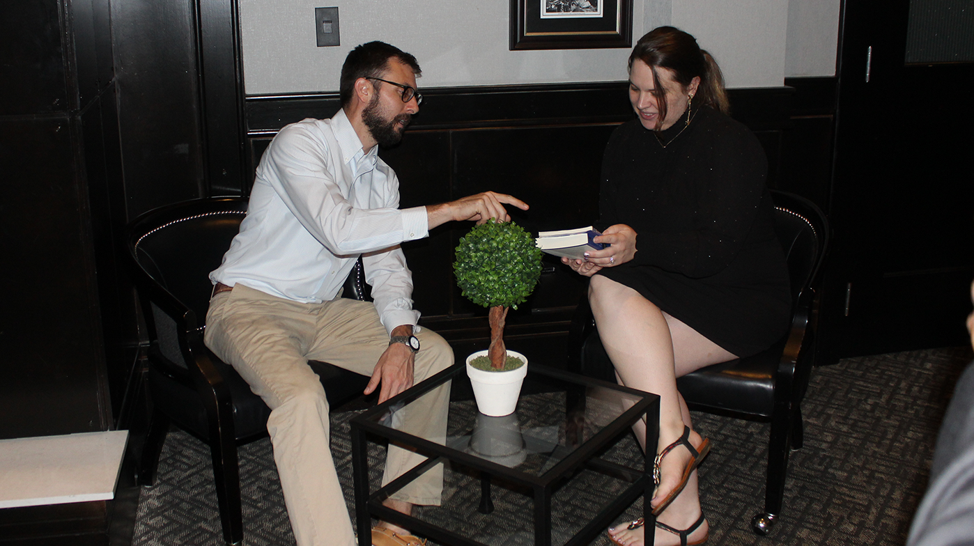 Kristin and a professor discussing a book.