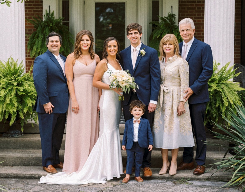 Zach Tarter on his wedding day standing next to his wife with both sets of parents on each side of them. 