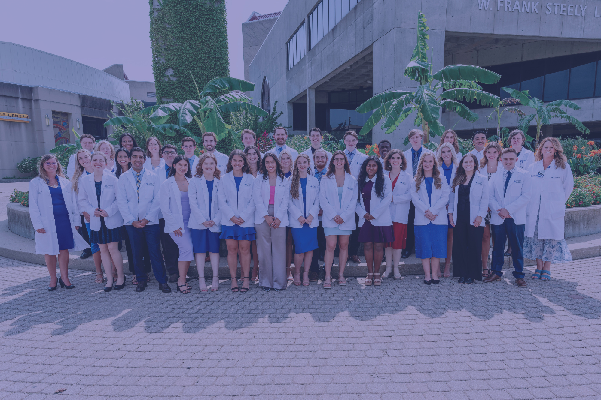 large group of students in white coats