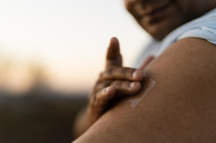 A person placing a nicotine patch on their arm.