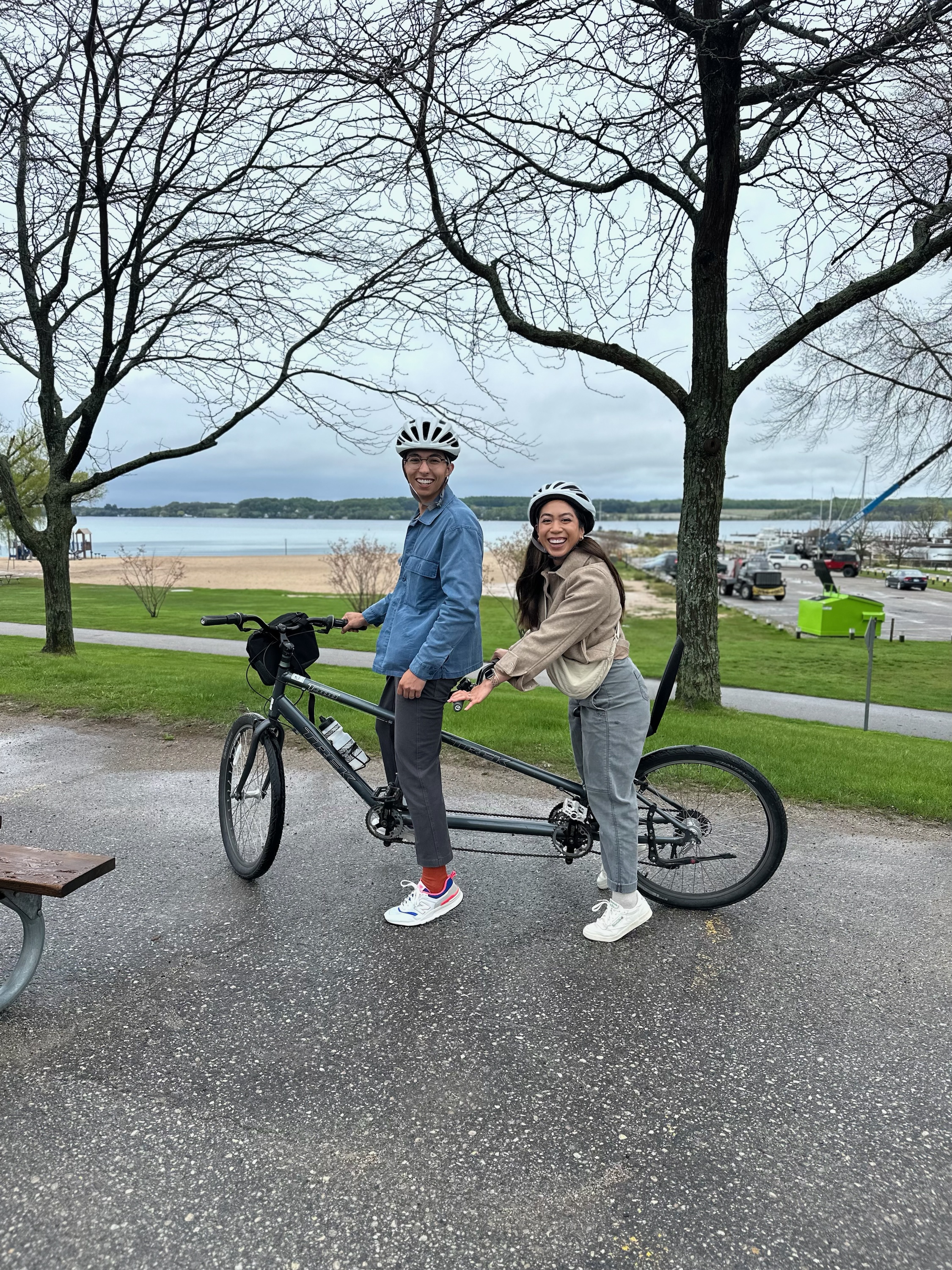 Jack and Wife posing in a park on a two person bike. 