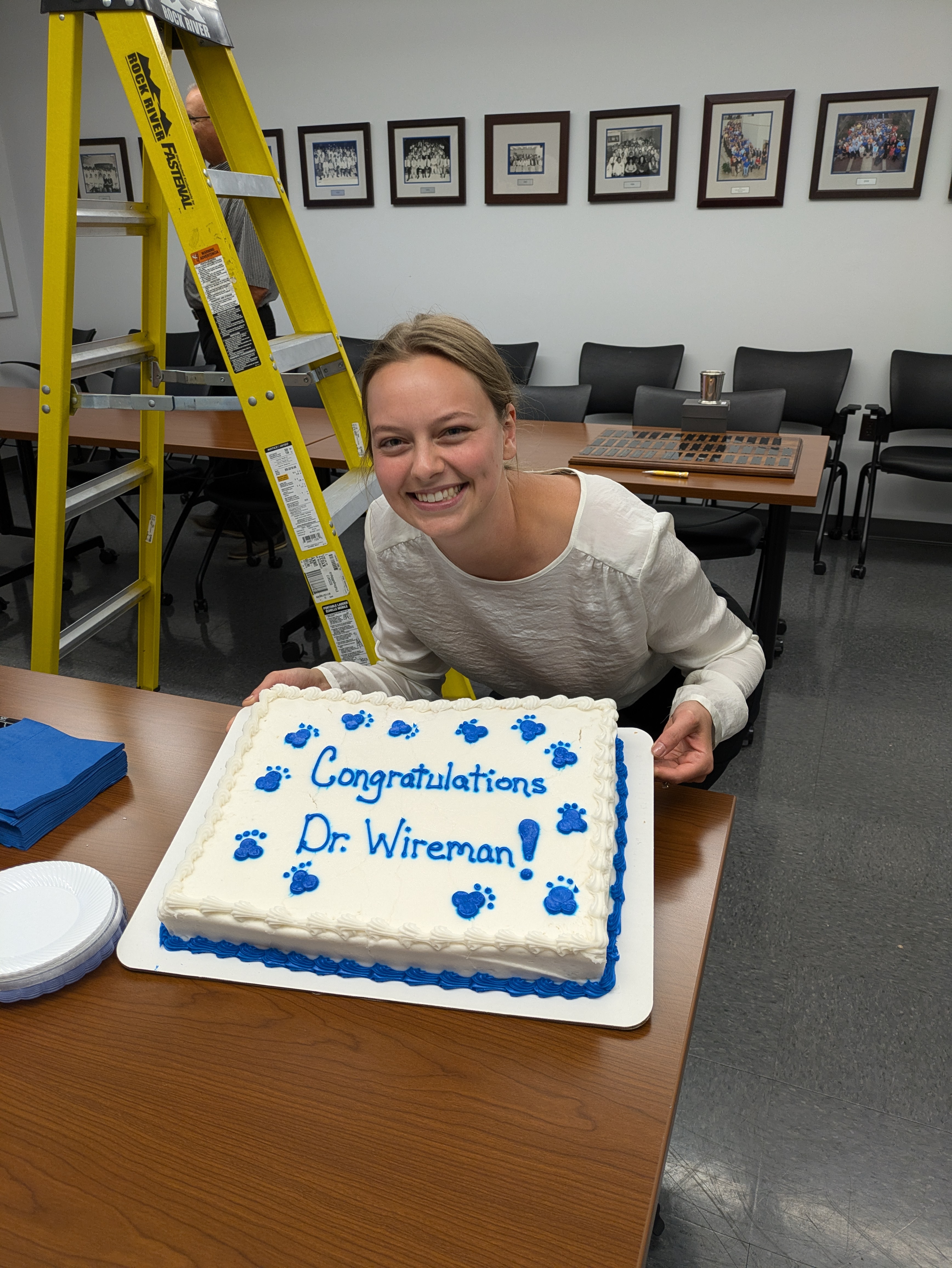 Olivia Wireman holding a cake that says "Congratulations Dr Wireman!"