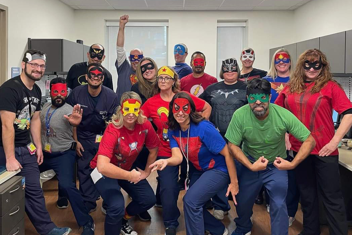 Pediatric fellows gathered and wearing superhero costumes.