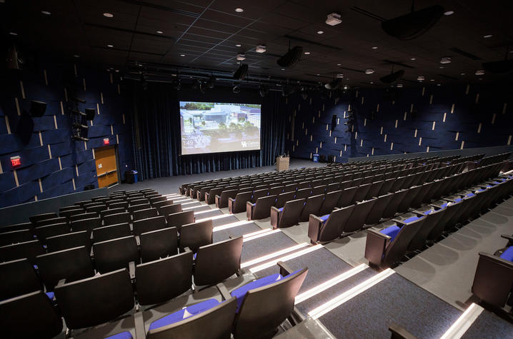 Worsham Theater - a large auditorium with weaving, blue walls, and a presentation screen at the front.