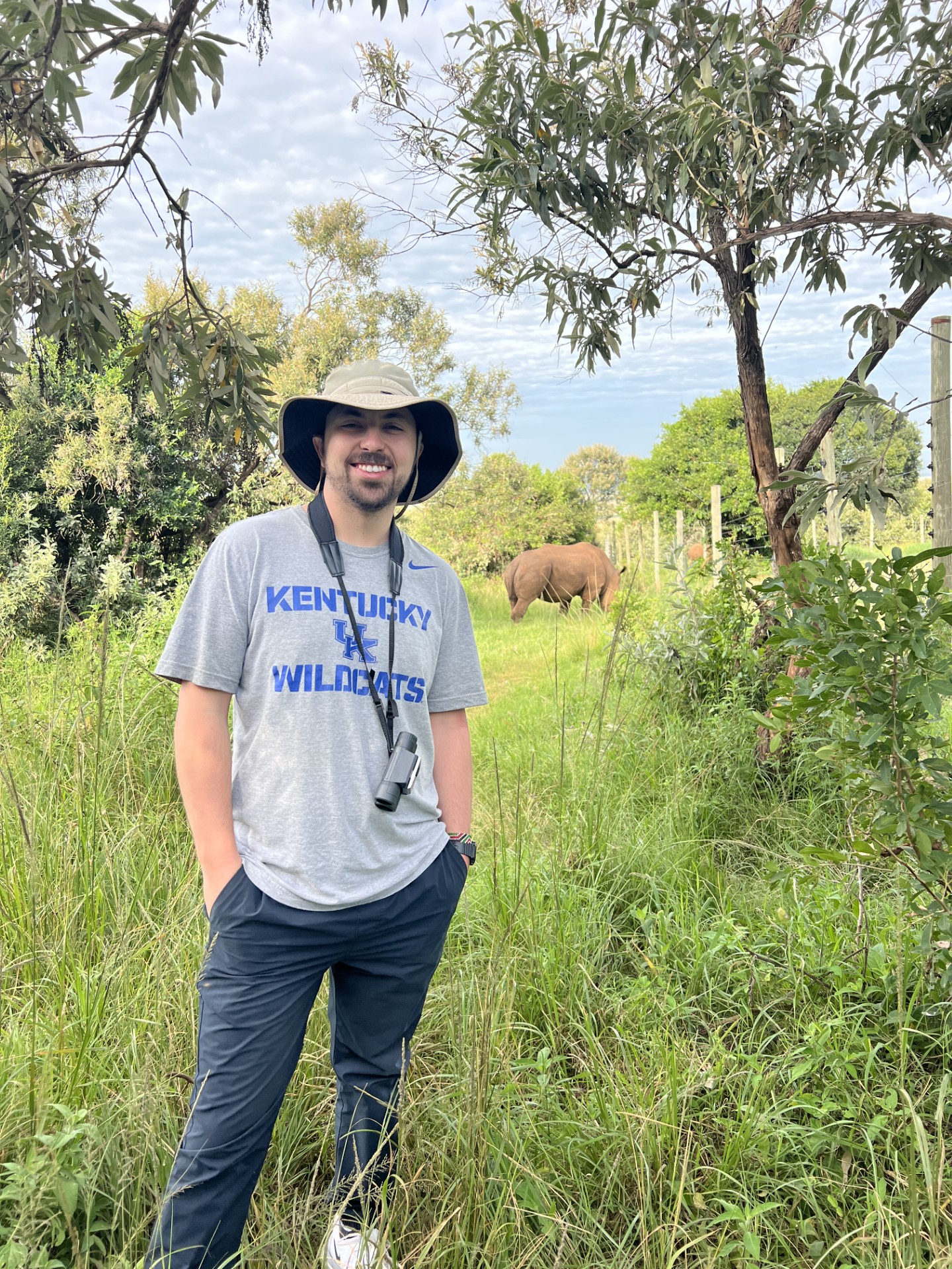 Andrew Kennedy on a safari, with a rhino in the background.