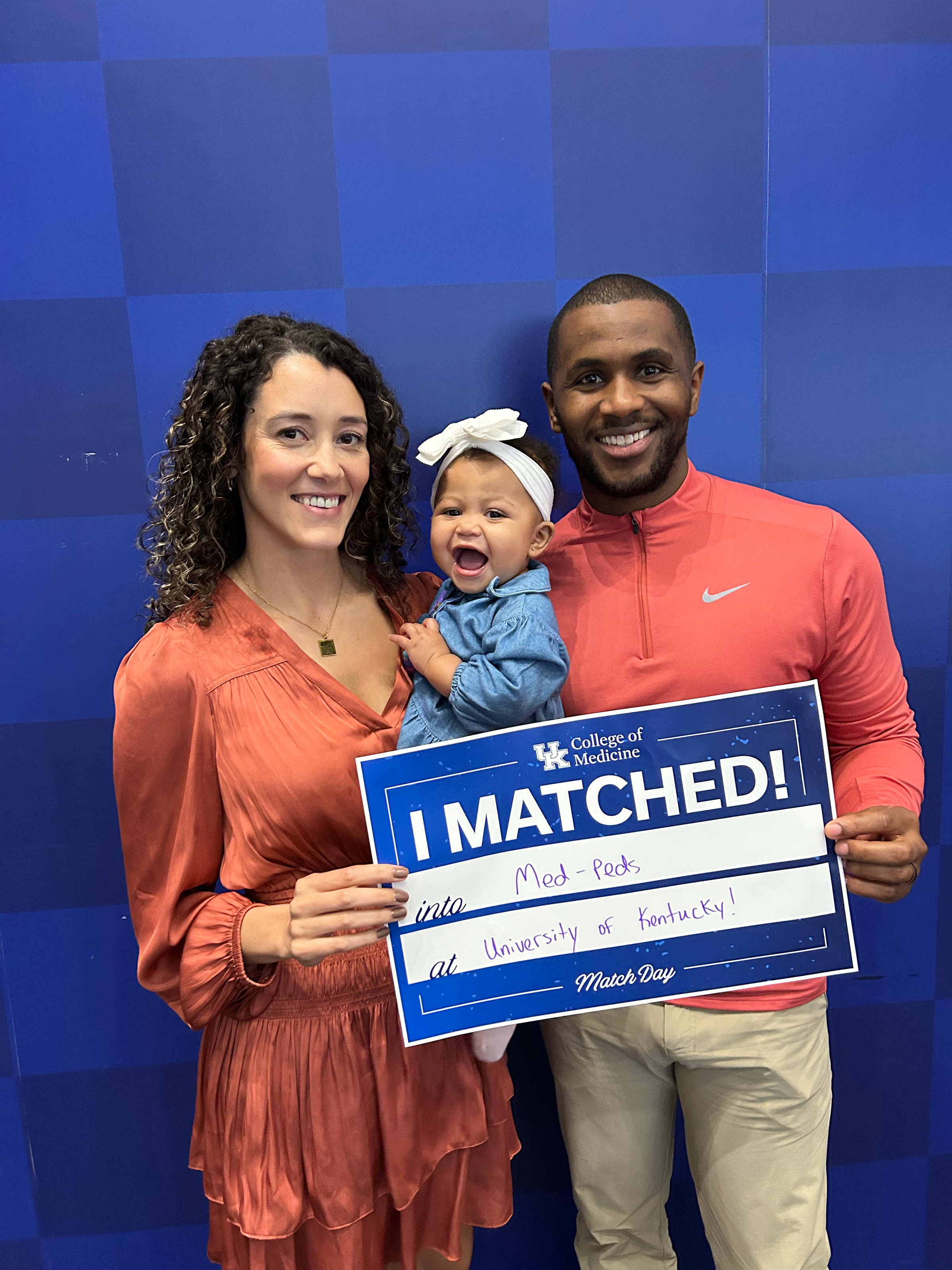 Kendall Noble-Halcomb and her family holding a sign that says "I MATCHED into Med-Peds at the University of Kentucky"