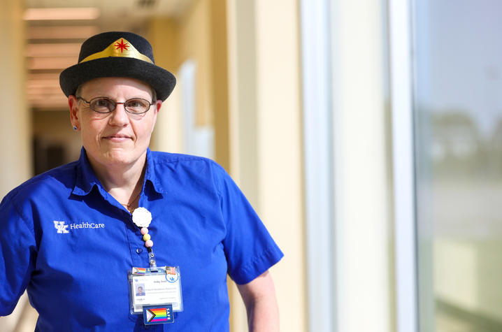 Trilby Trent in UK blue scrubs, and a trilby hat.