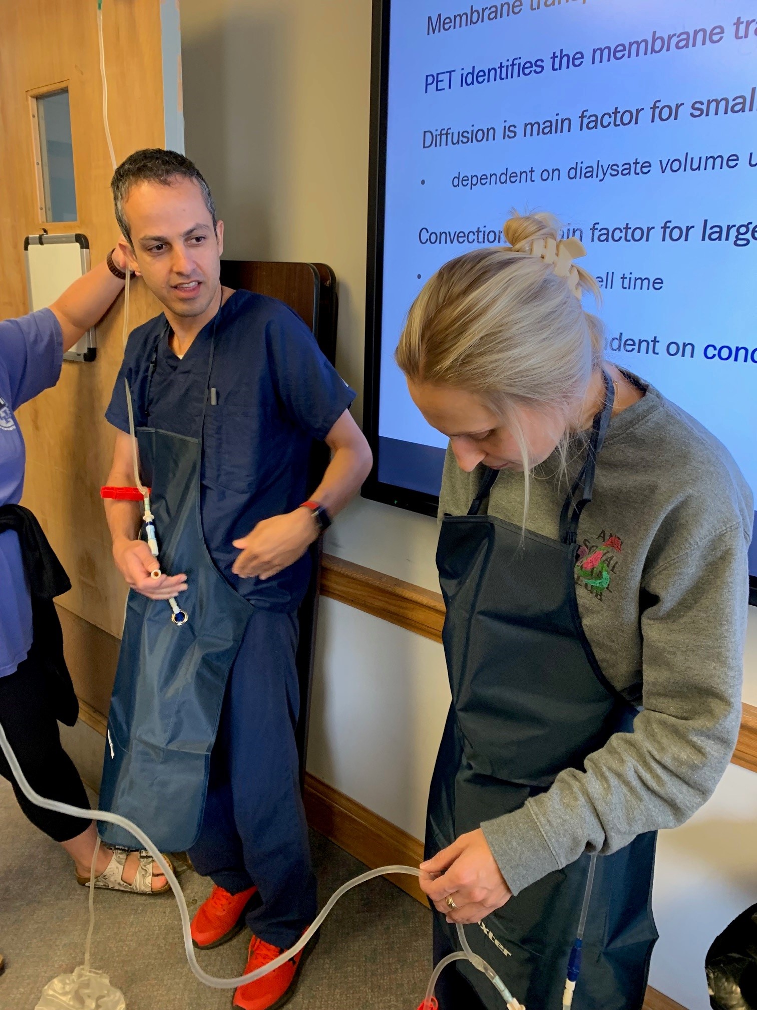 A Nephrology Fellow being directed on where a saline bag would connect