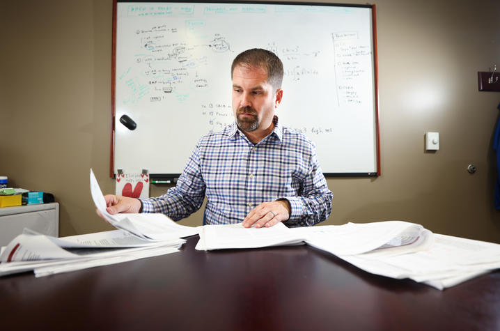 David Fardo looking through paperwork on his desk.