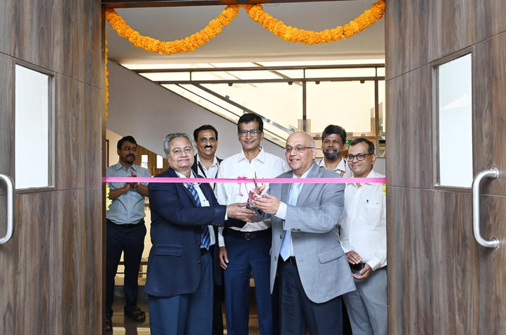 Rangnekar, third from right, and colleagues from India cut a pink ribbon to their new facilities.