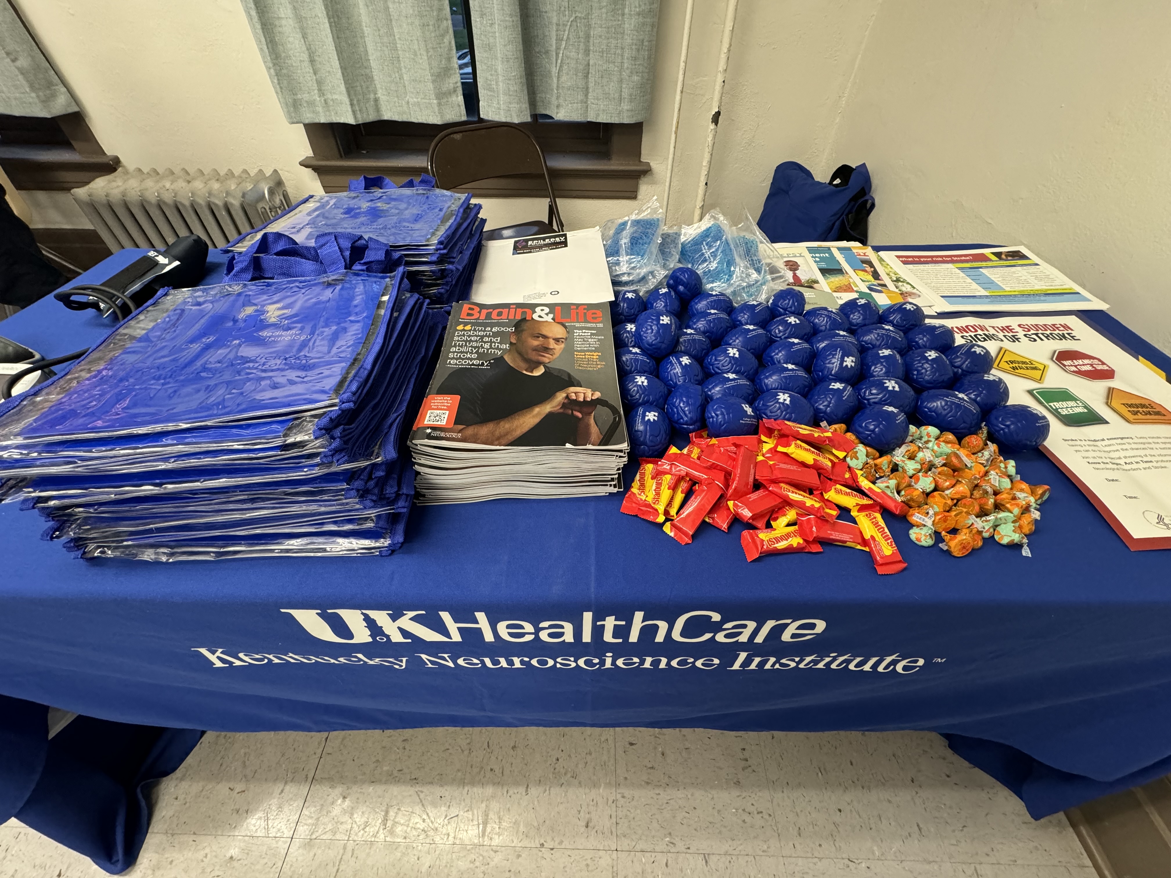 Flyers, handouts, and gifts on a table for the Men's Health event