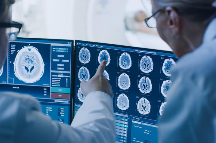 Two medical professionals looking over brain scans