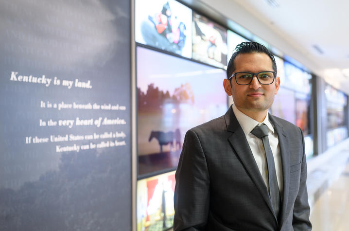 Avinash S. Bhakta, MD in front of the photo wall at UK Albert B. Chandler hospital.