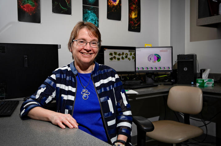 Linda Van Eldik sitting in a computer lab, leaning against a table.