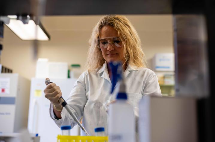 Julie Pendergast working in the lab with a pipette. 