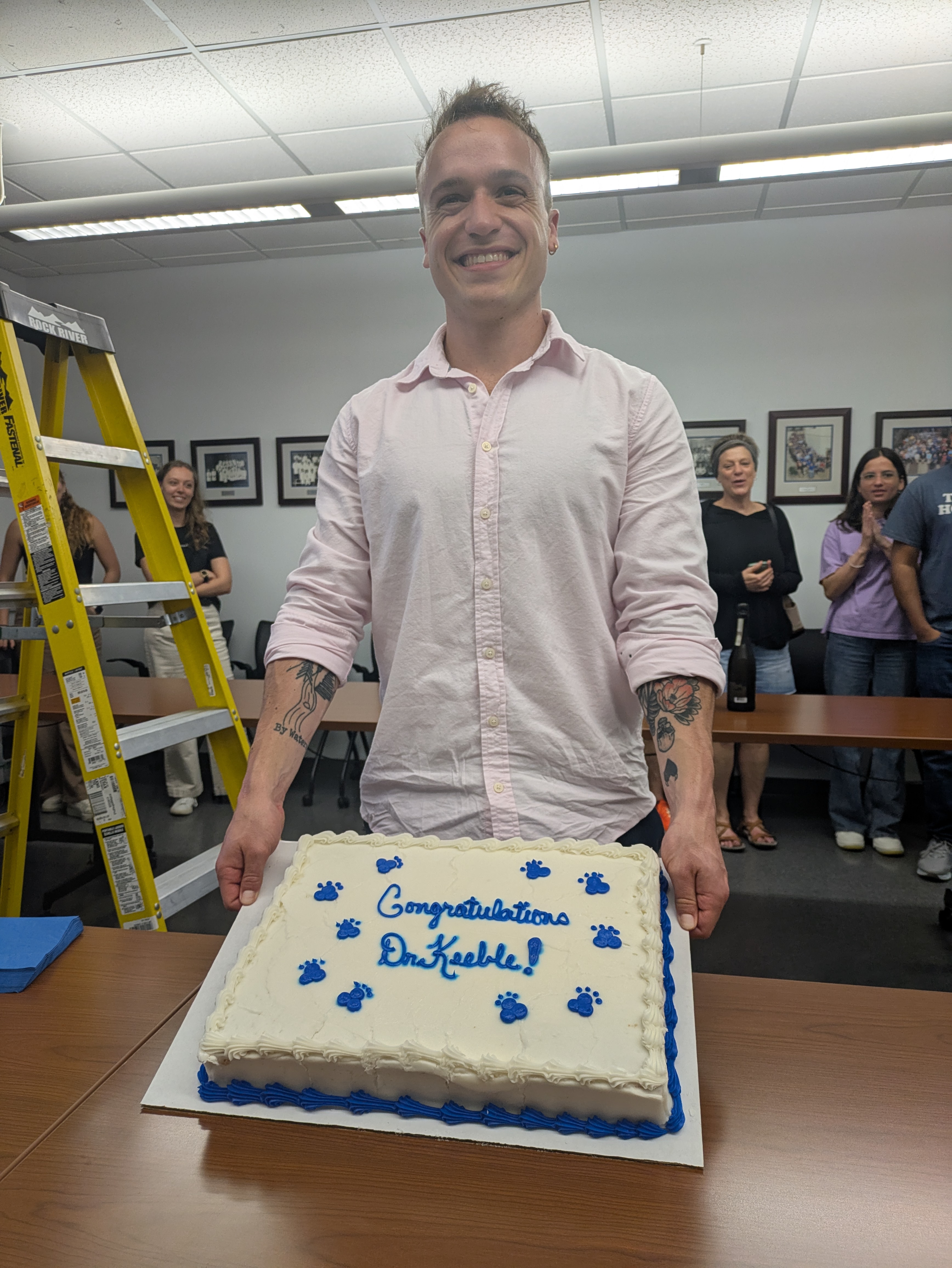 Picture of Dr Keeble holding a cake that says, "Congratulations Dr. Keeble".