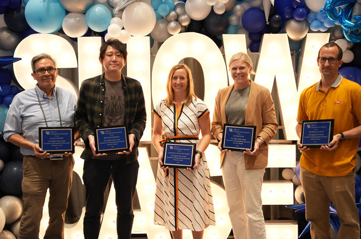 The five winners of the undergraduate research mentoring award, standing in front of a sign reading, "SHOWCASE"