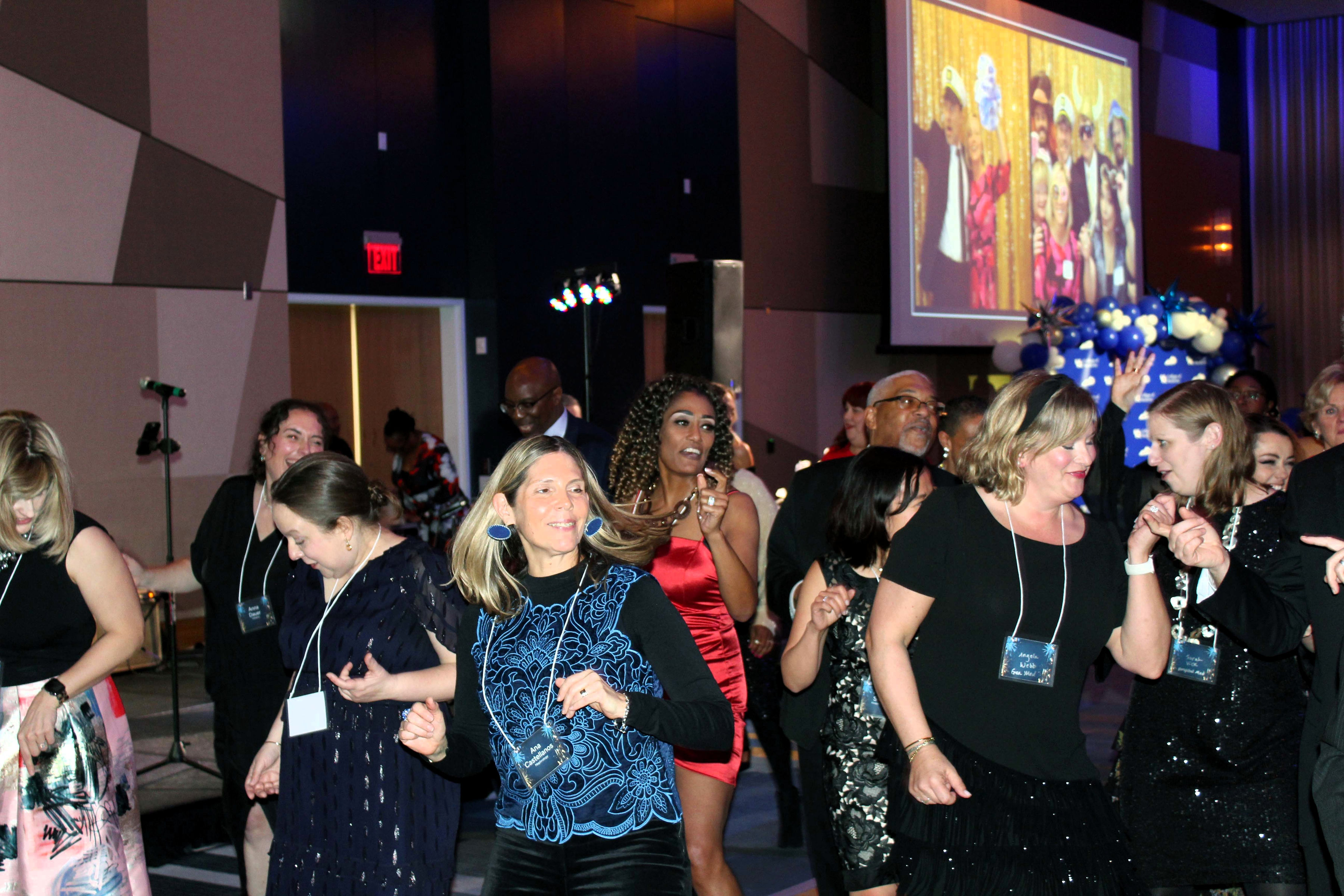A group dance on the dance floor beneath some bright lights