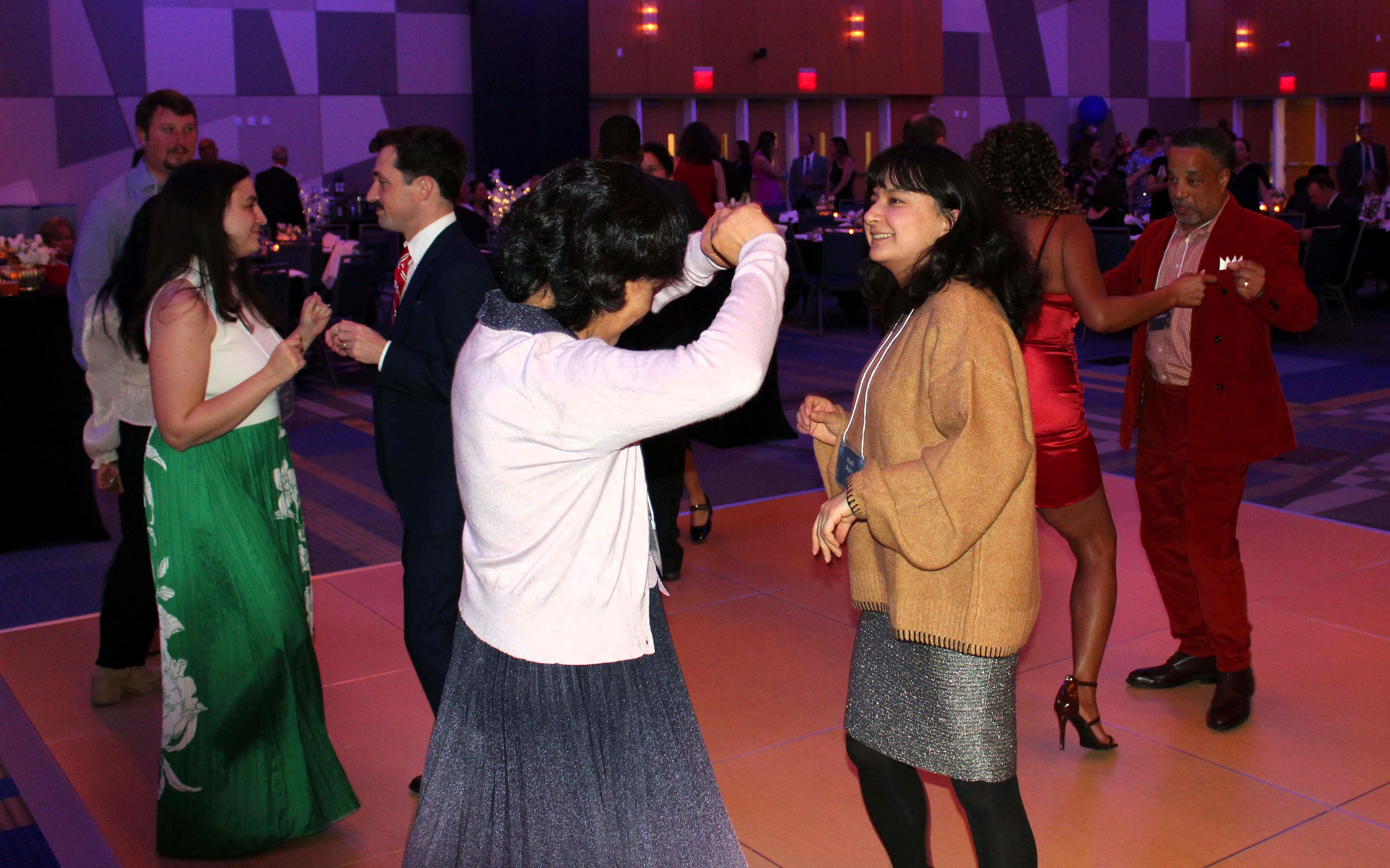 People in dance in pairs on a dance floor