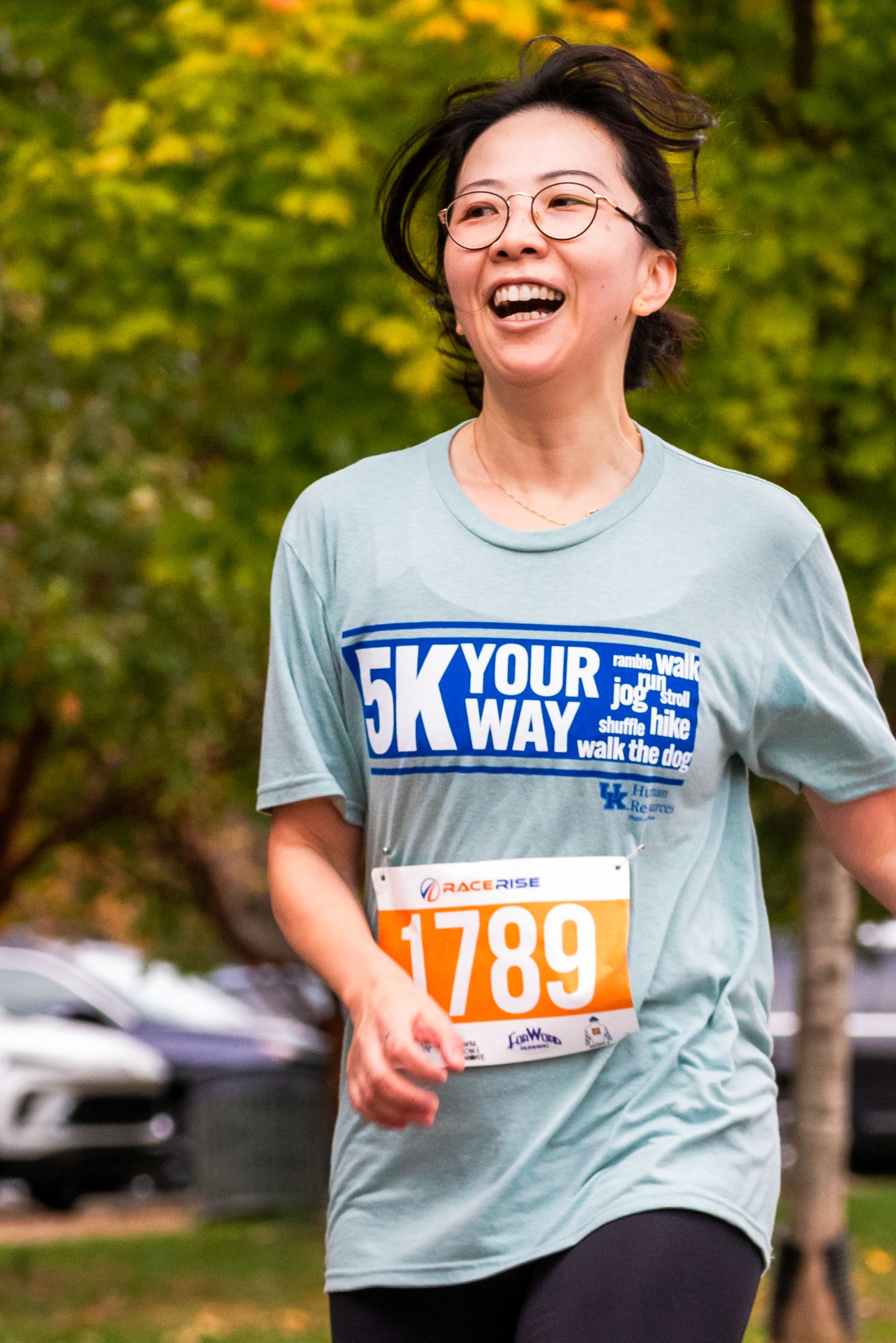 A woman runs with a large smile on her face