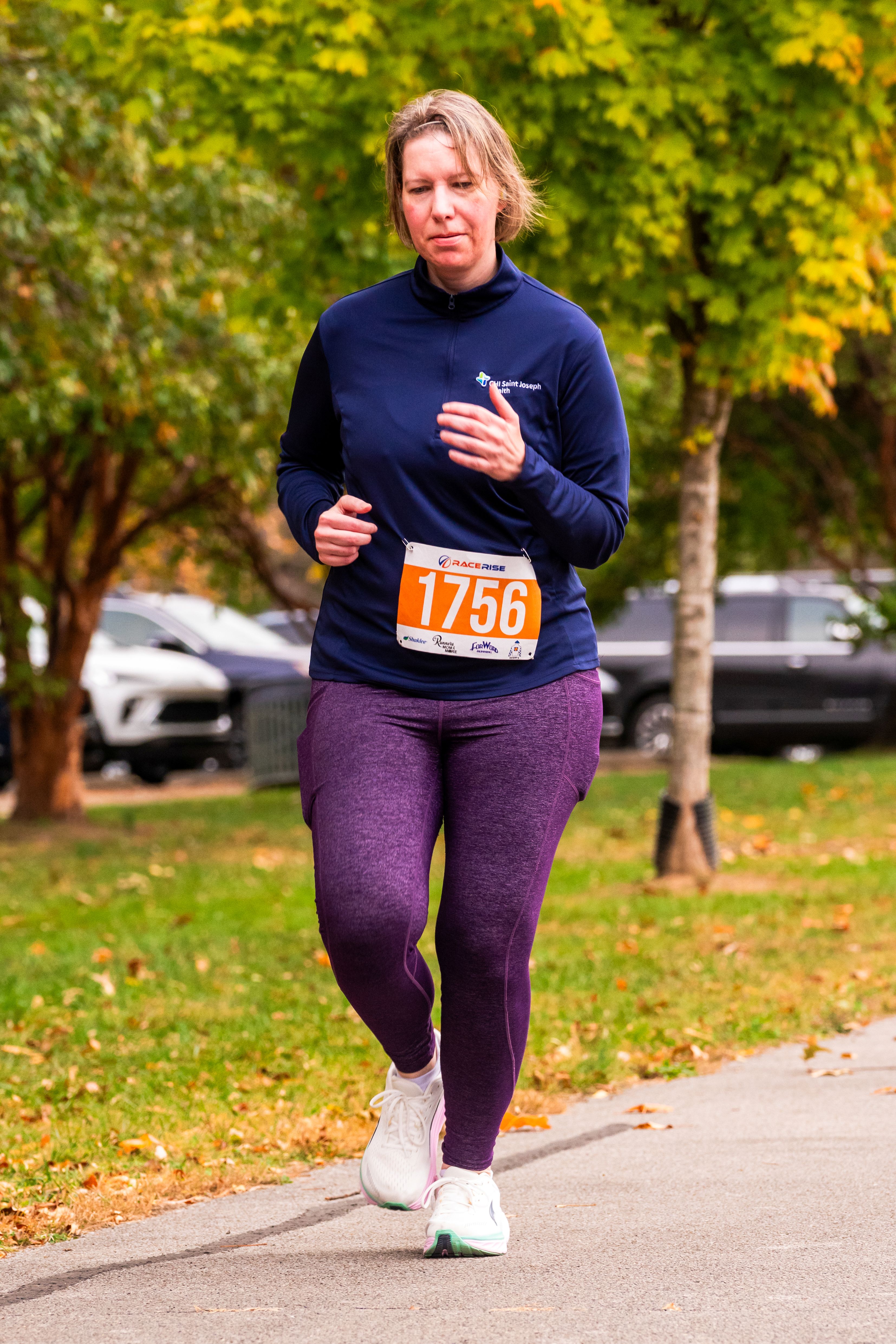 A woman runs with a focused look on her face