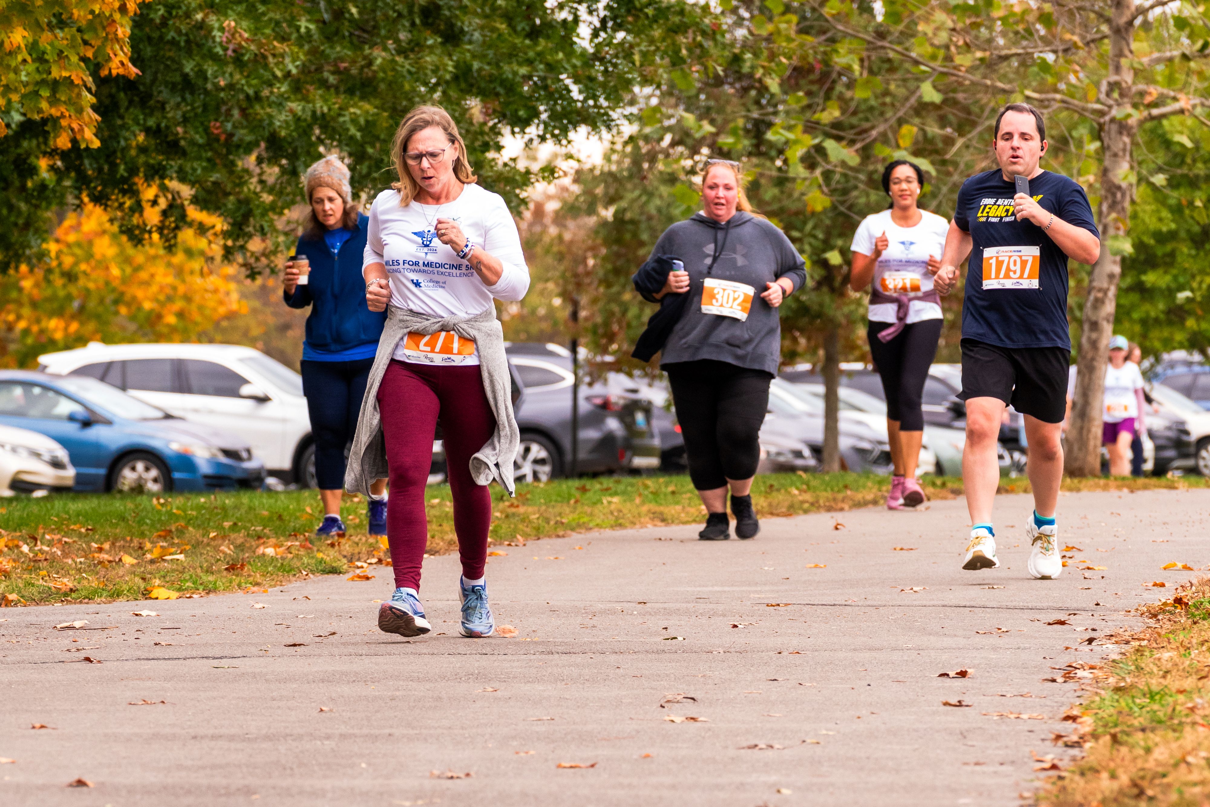 A group of five people run at varying depths. They look tired but focused