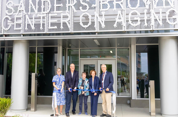 Sanders-Brown faculty cutting a blue ribbon at the grand reopening of their building.