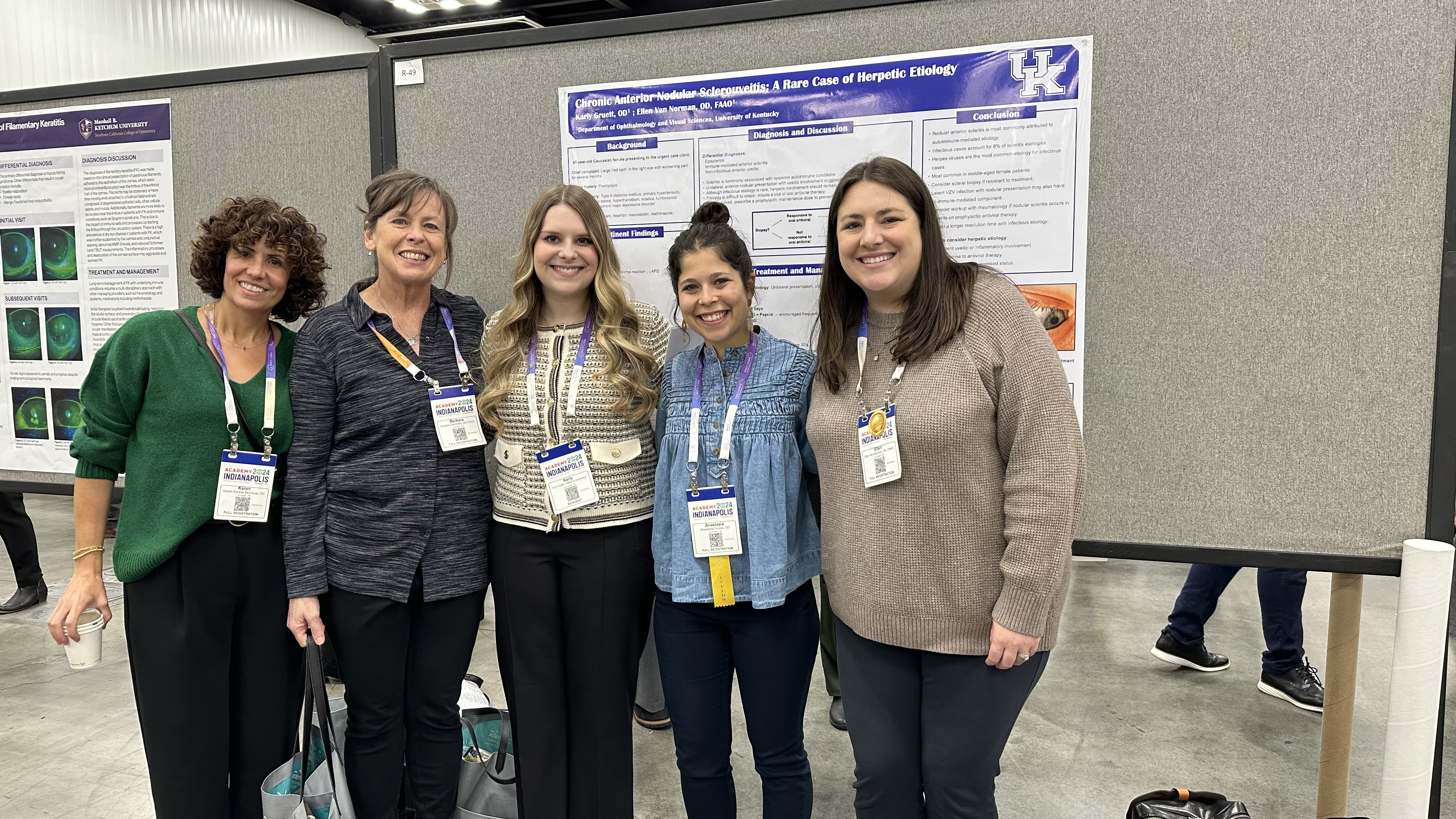 Optometry faculty and resident standing infront of research posters