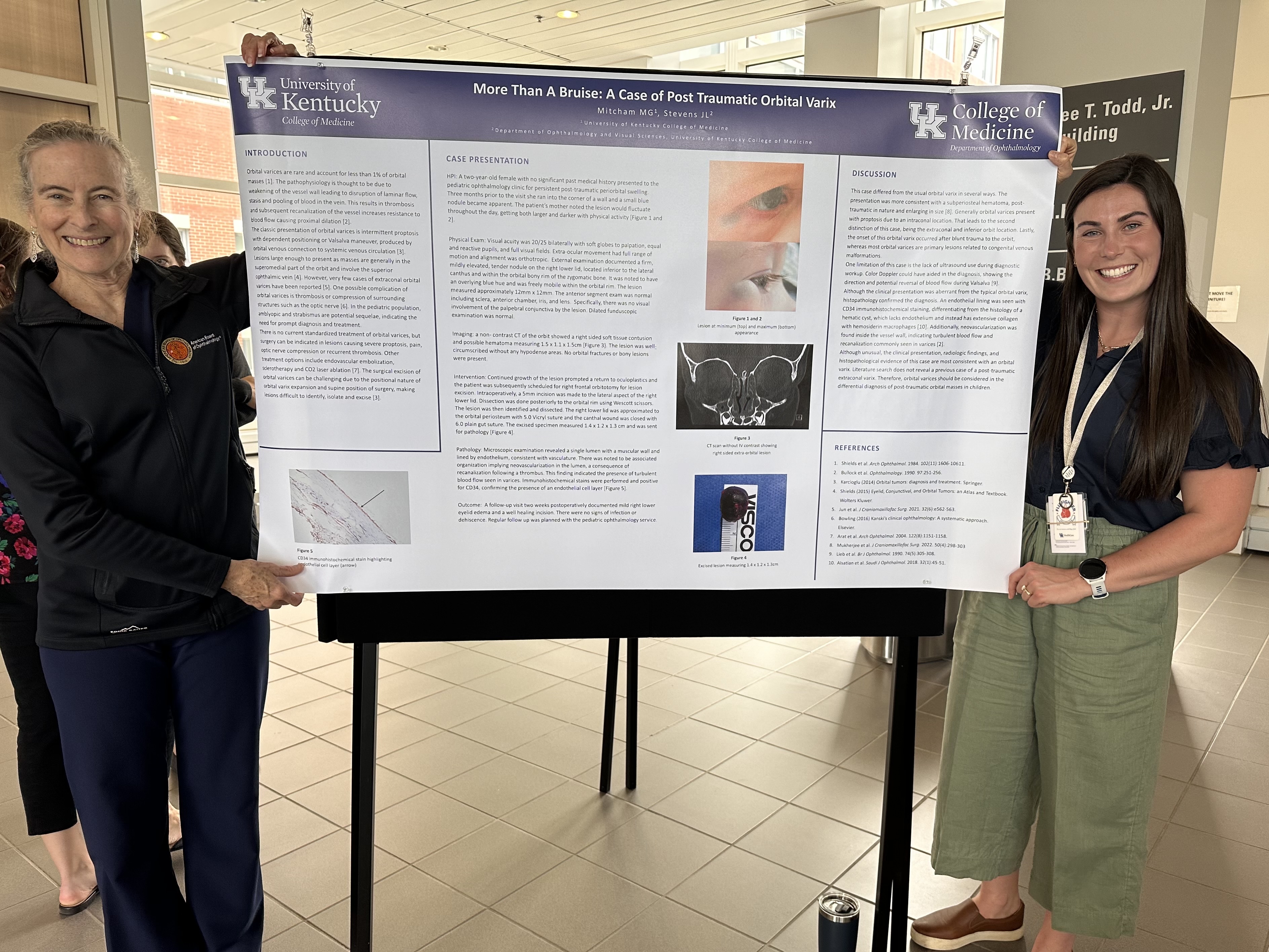 Resident Maddie Mitcham and Dr. Stevens holding up a research poster and smiling. 