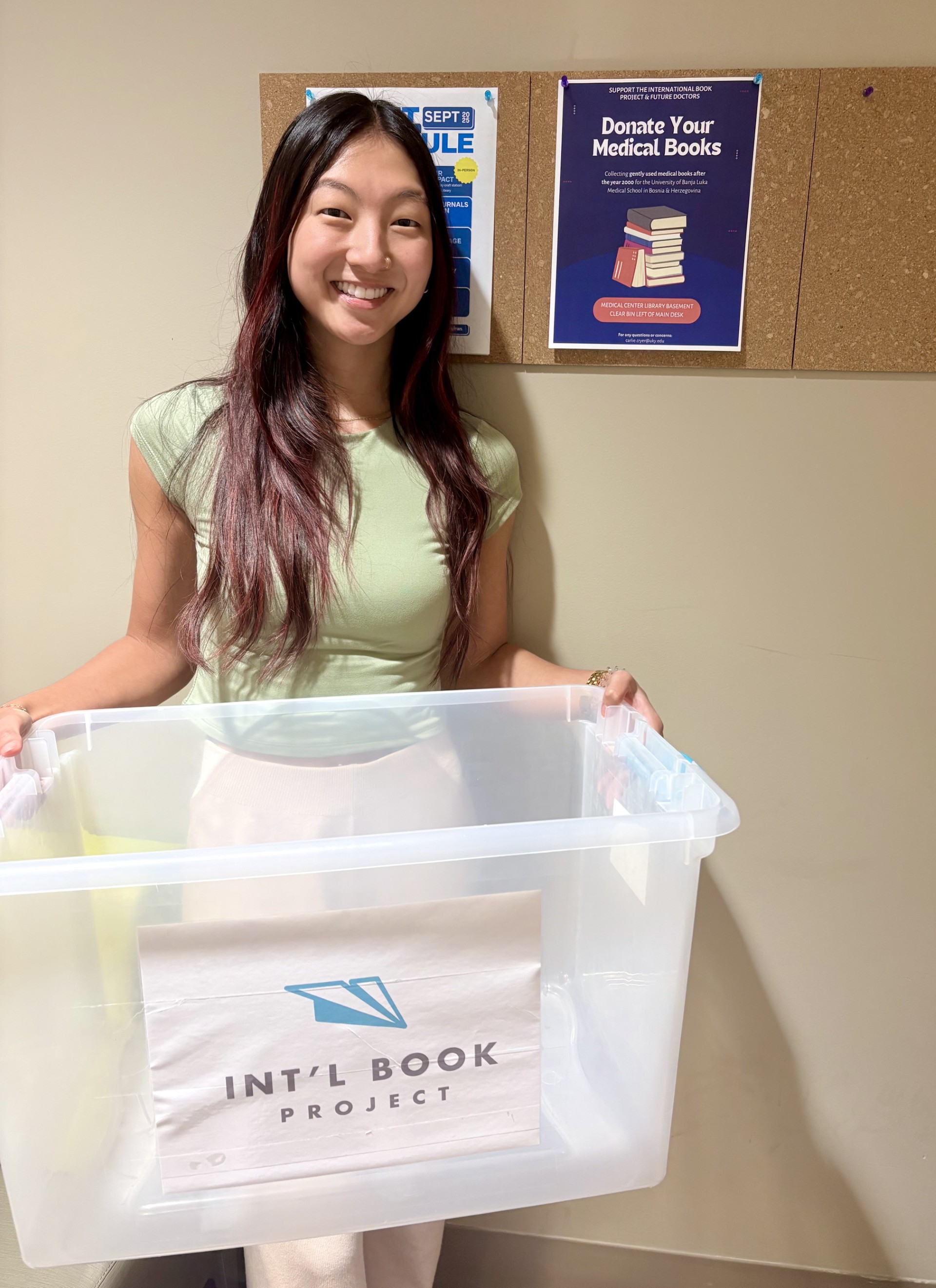 Med student poses with empty storage tote to advertise medical textbook donation drive