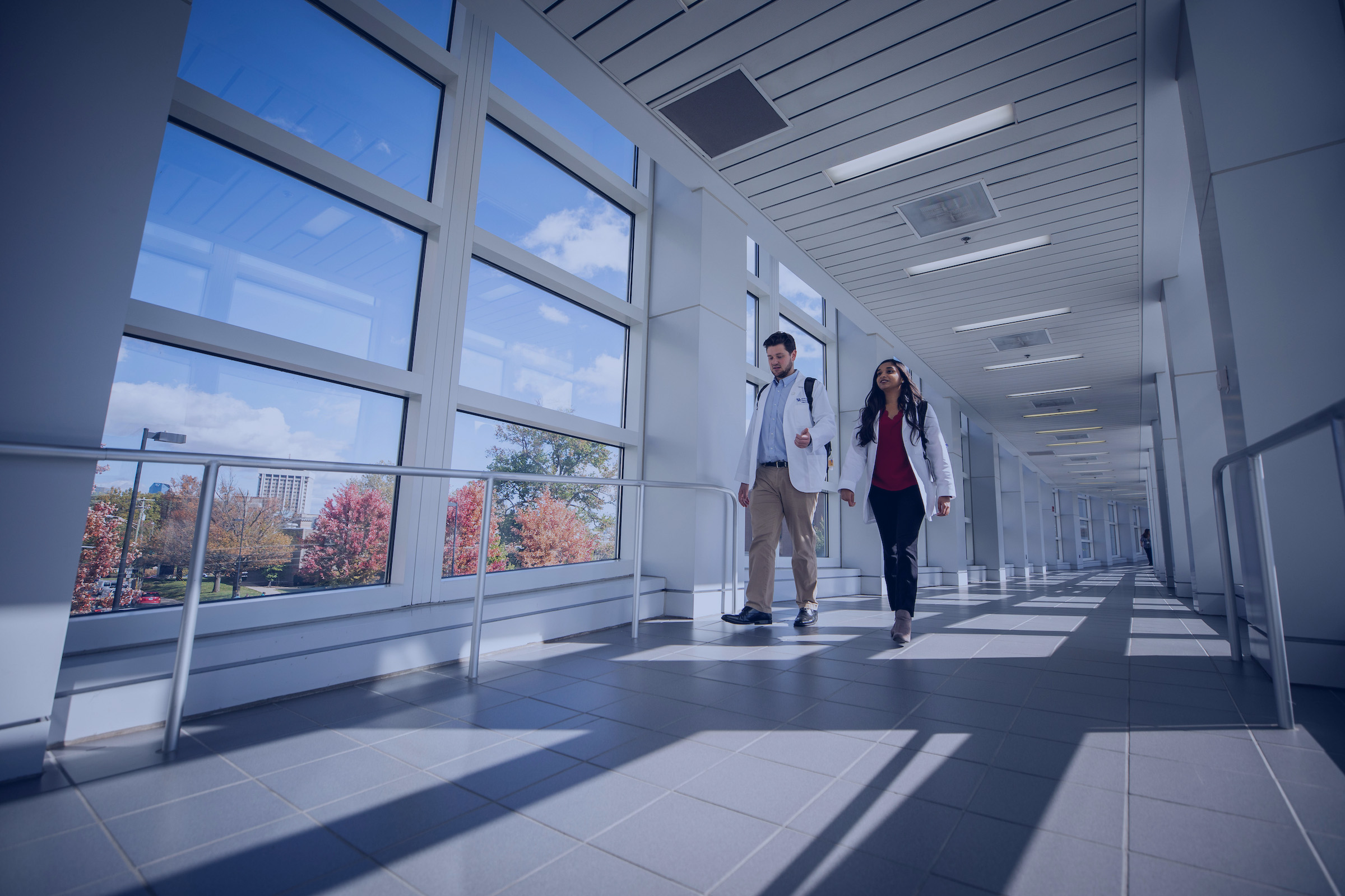 students walking through a bridge with a blue overlay
