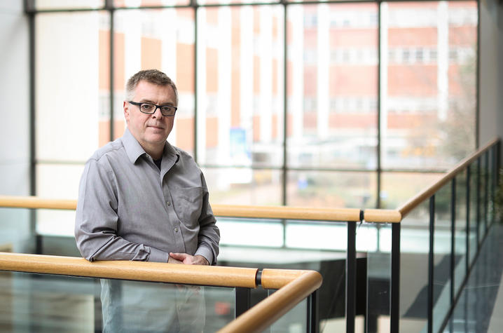 Paul Murphy leaning on the railing at the top of a set of stairs.