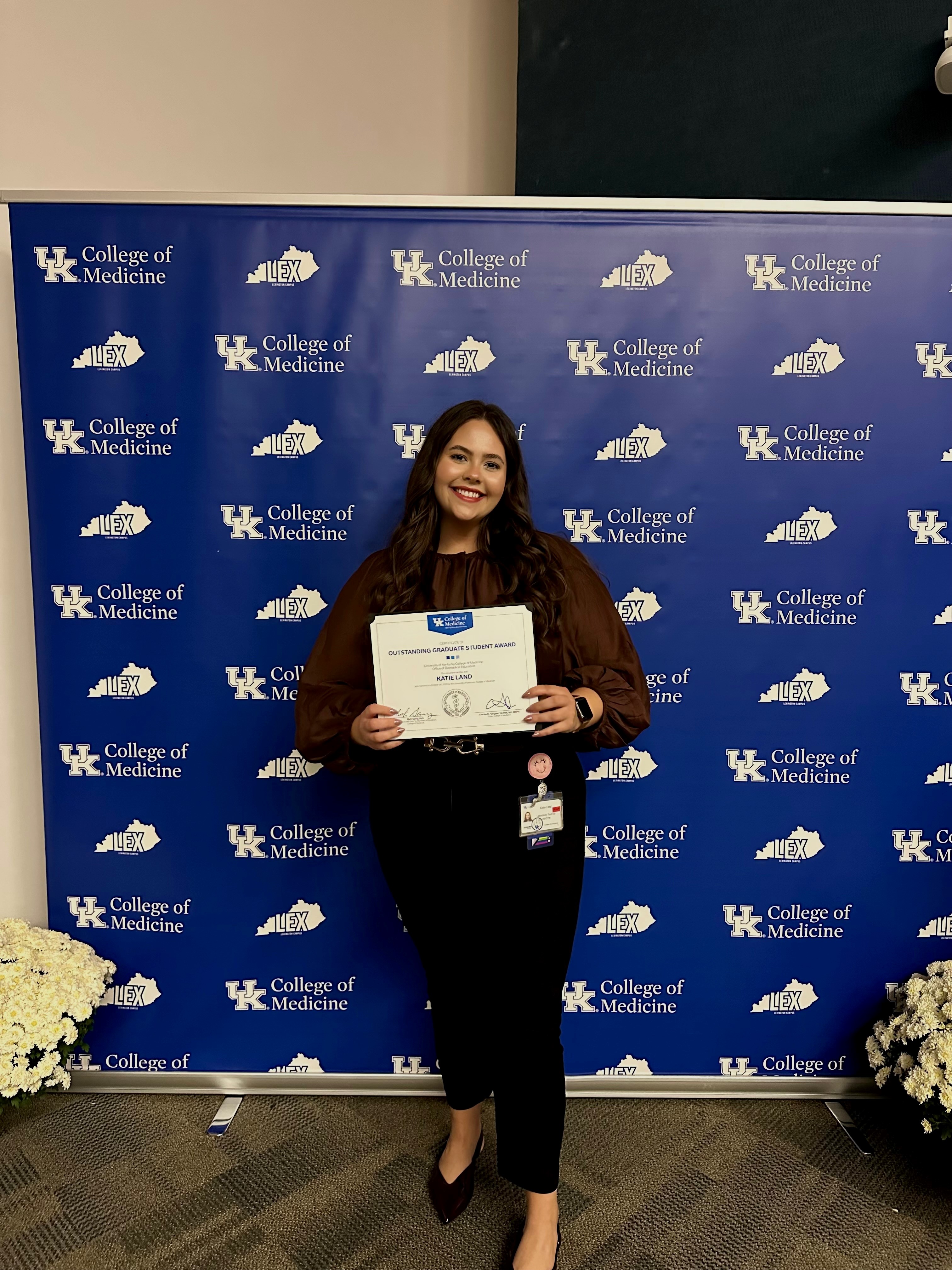 A photograph of a DPNS Graduate Student with her Graduate Student of the Year award