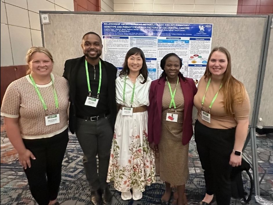 The Moore lab members, standing in a row of five in front of a presentation