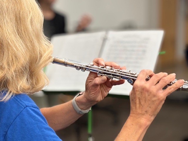 Woman with blonde hair playing the flute