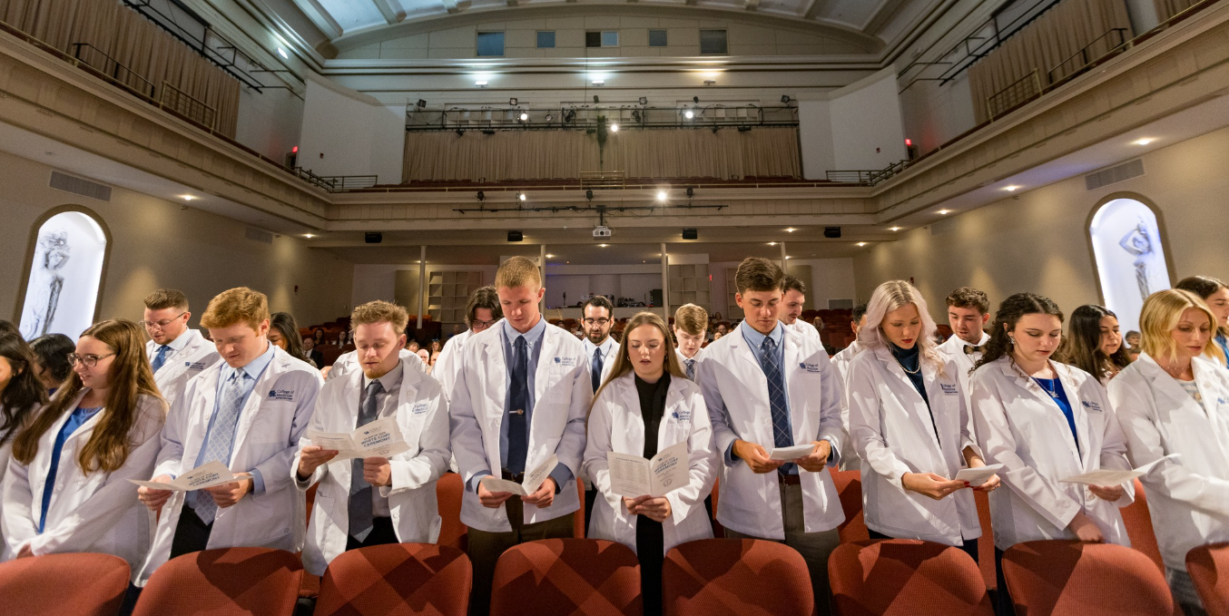 Large group of students reciting pledge during white coat ceremony